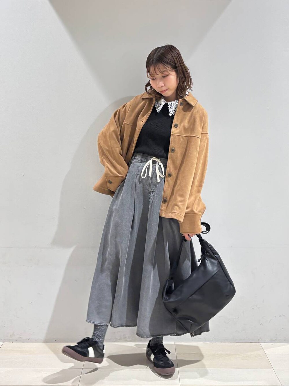 ブラック系のスニーカー、ブラック系のショルダーバッグ、ブラウン系のテーラードジャケットを着用したレディースの冬コーディネートの6枚目の写真