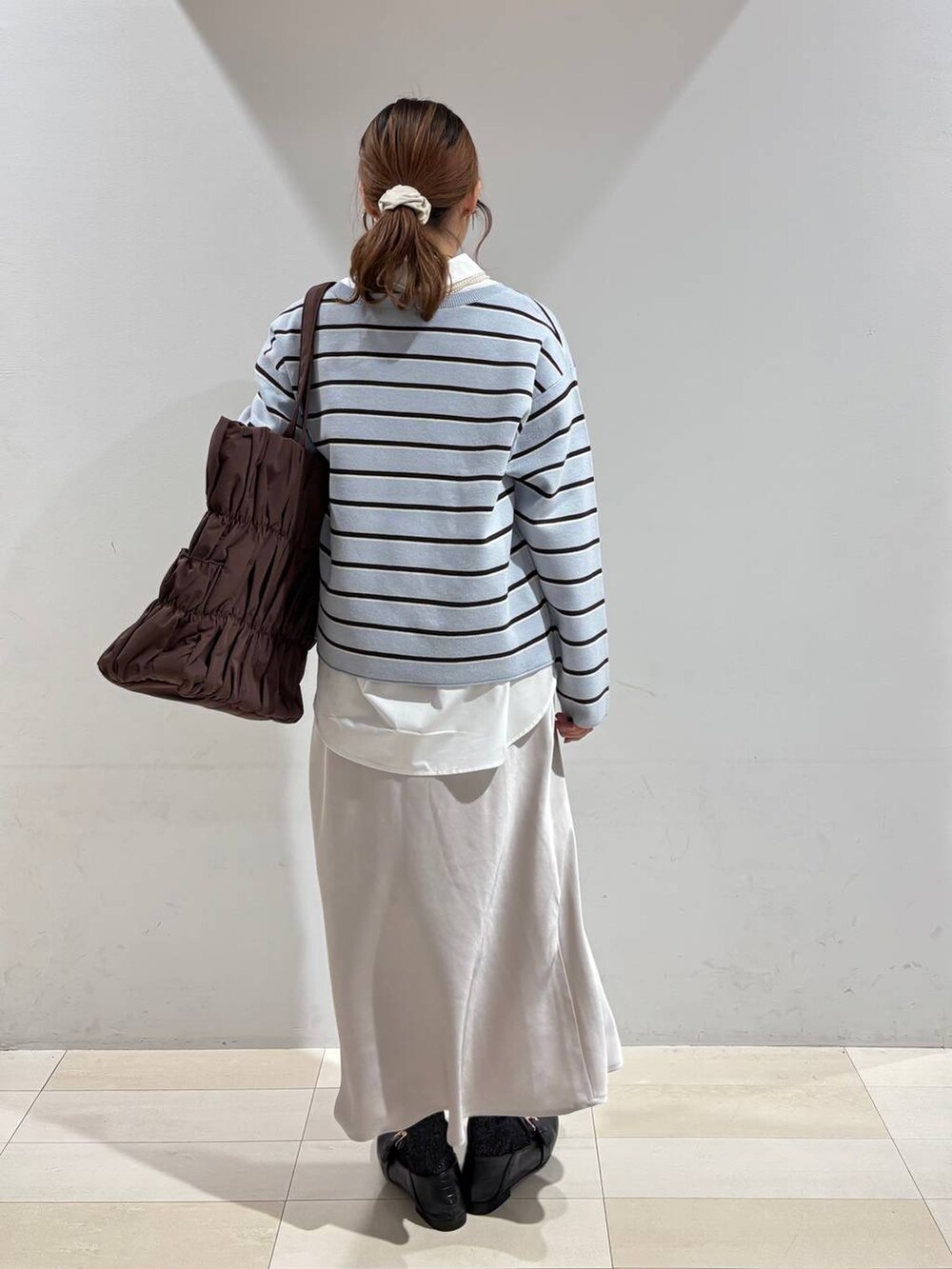 ブラック系のローファー、ブラウン系のトートバッグ、ブルー系のニット/セーターを着用したレディースの冬コーディネートの5枚目の写真