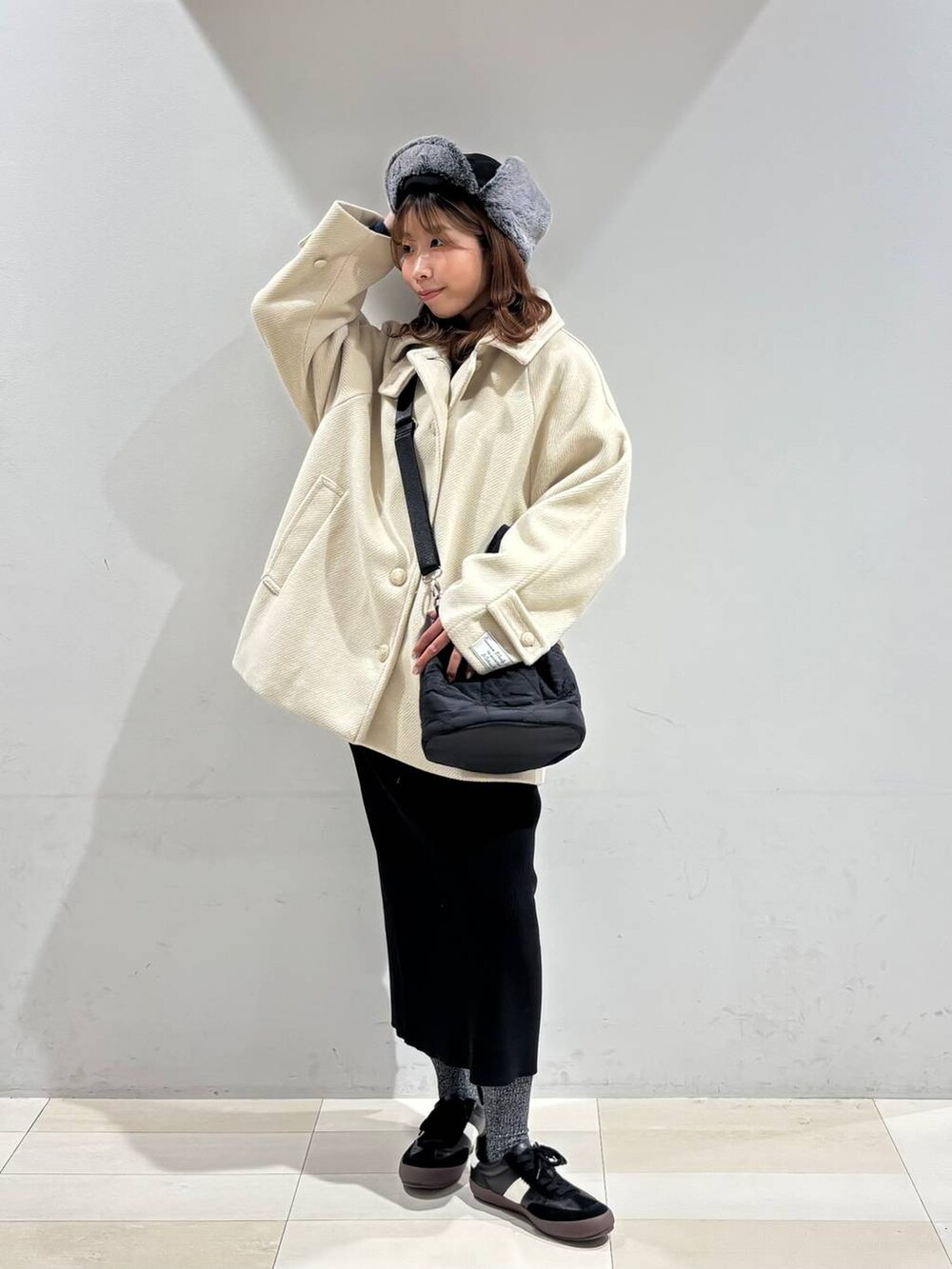 ブラック系のスニーカー、ブラック系のハンドバッグ、ブラック系のスカートを着用したレディースの冬コーディネートの5枚目の写真