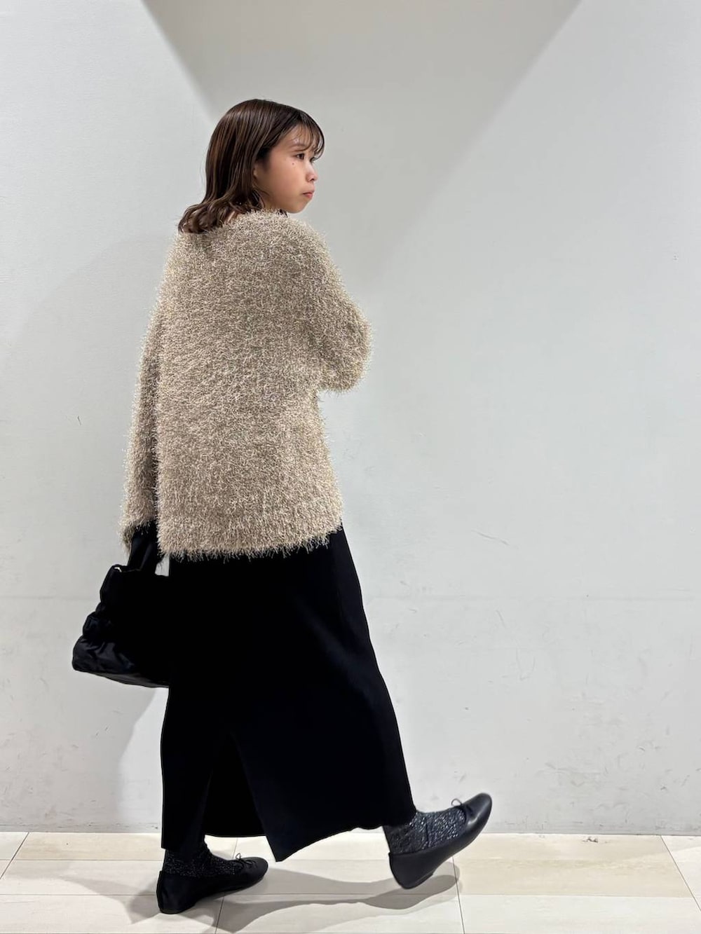 ブラック系のバレエシューズ、ブラック系のトートバッグ、ブラック系のスカートを着用したレディースの春コーディネートの5枚目の写真