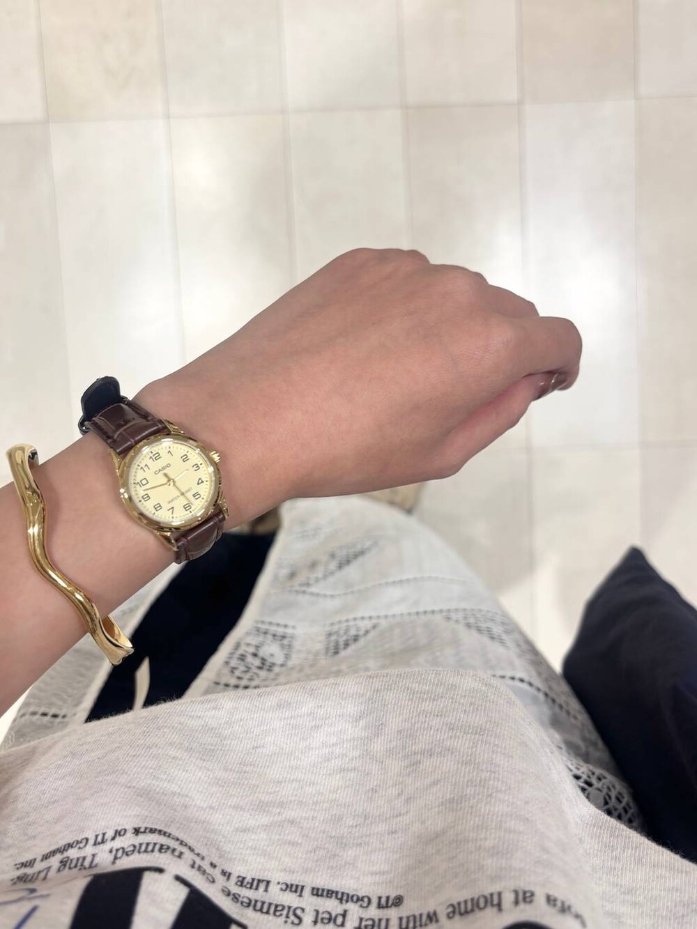 ブルー系のデニムパンツ、グレー系のTシャツ/カットソー、ゴールド系のネックレスを着用したレディースの秋コーディネートの4枚目の写真