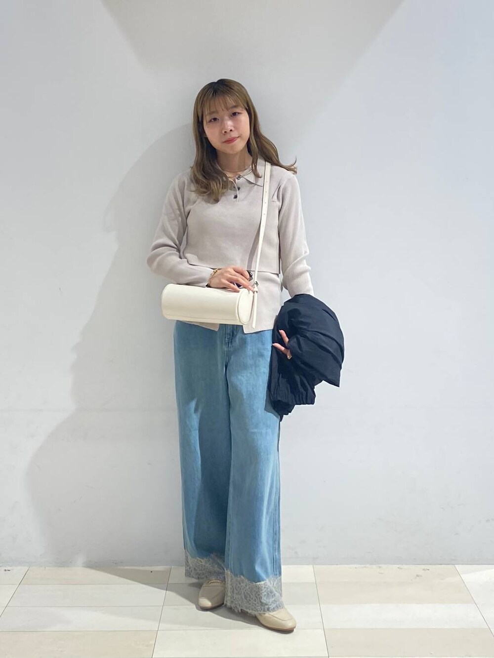 ベージュ系のTシャツ/カットソー、ホワイト系のクラッチバッグ、ホワイト系のローファーを着用したレディースの秋コーディネートの8枚目の写真