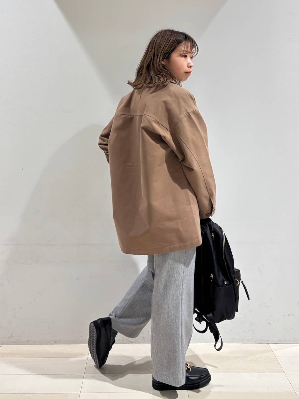 ブラック系のローファー、ブラック系のバックパック/リュック、グレー系のその他パンツを着用したレディースの春コーディネートの7枚目の写真