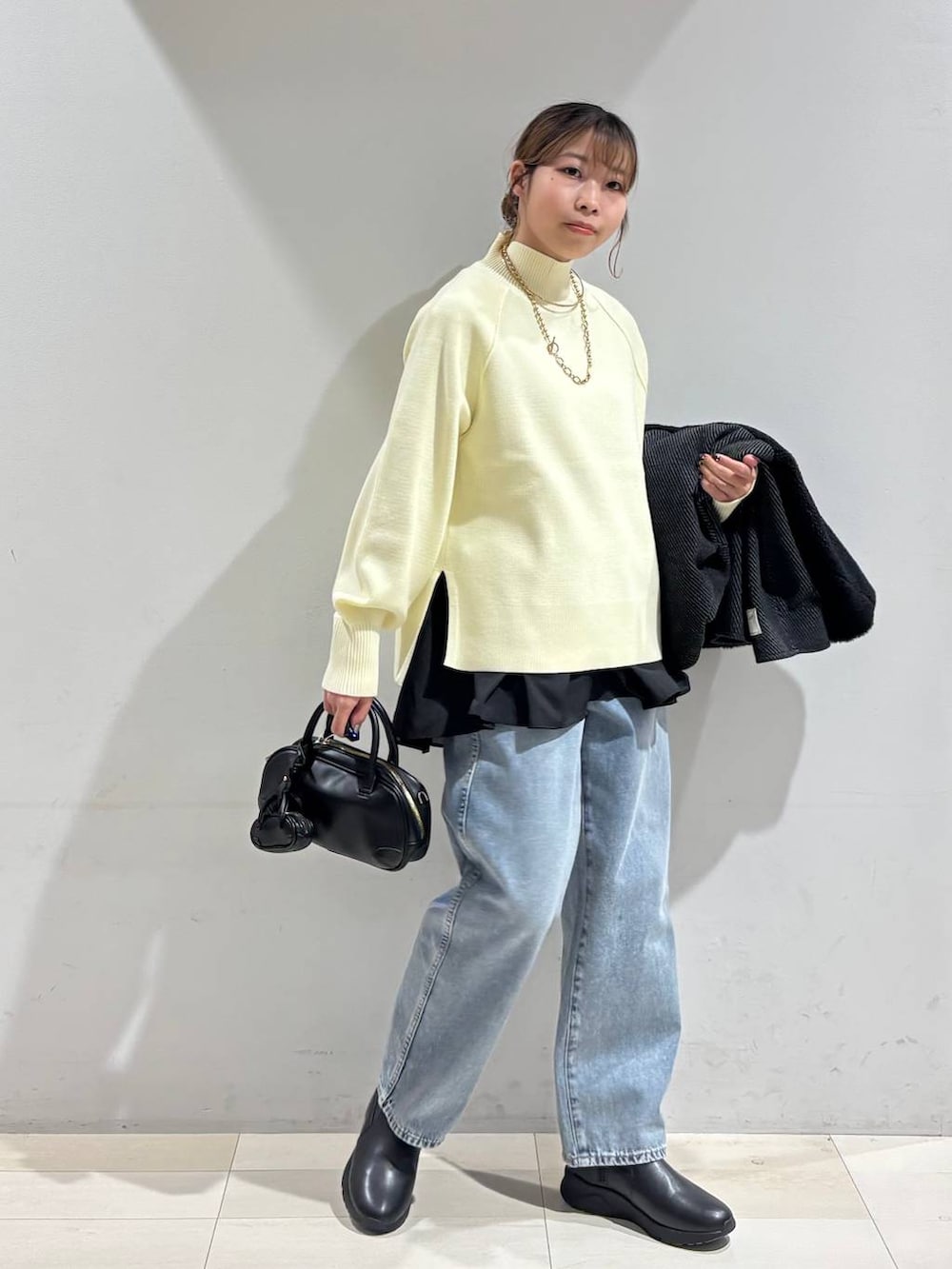 ブルー系のデニムパンツ、ブラック系のブーツ、ブラック系のTシャツ/カットソーを着用したレディースの冬コーディネートの3枚目の写真