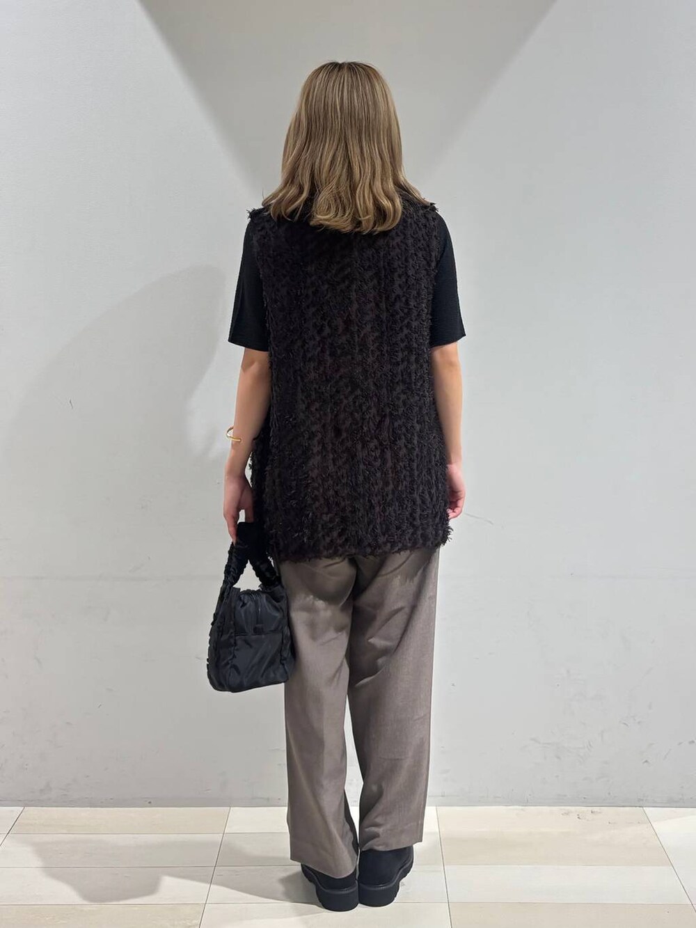 ブラック系のショルダーバッグ、ブラック系のTシャツ/カットソー、ブラック系のローファーを着用したレディースの秋コーディネートの4枚目の写真