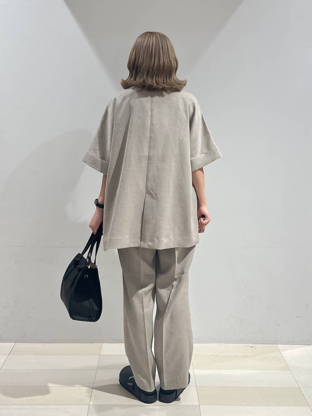 ブラック系のショルダーバッグ、ホワイト系のキャミソール、ブラック系のサンダルを着用したレディースの夏コーディネートの3枚目の写真