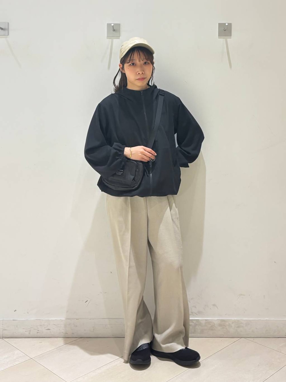 ベージュ系のその他パンツ、ブラック系のマウンテンパーカー、ブラック系のスニーカーを着用したレディースの春コーディネートの2枚目の写真