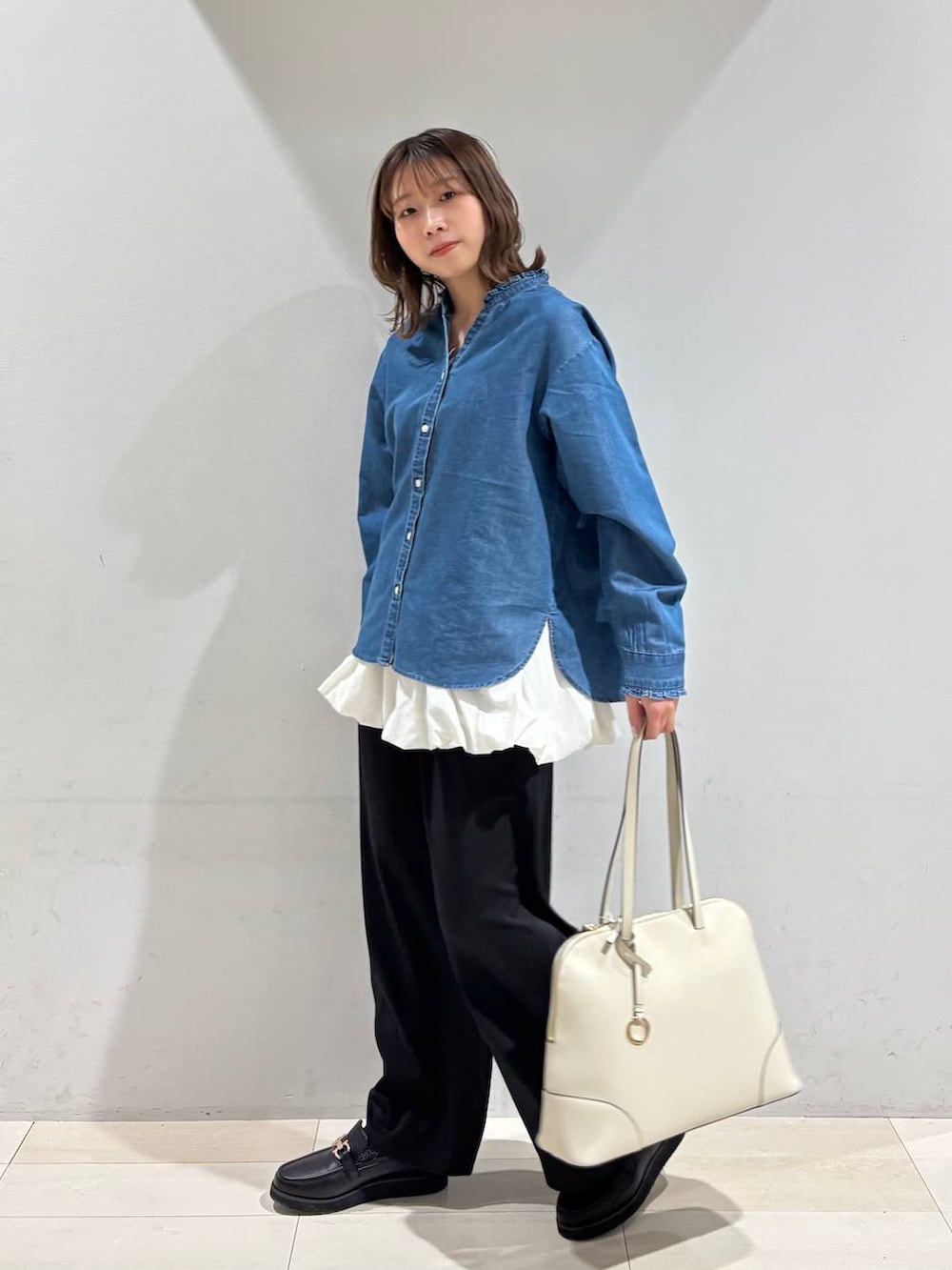 ブラック系のローファー、ベージュ系のボストンバッグ、ブルー系のシャツ/ブラウスを着用したレディースの春コーディネートの4枚目の写真