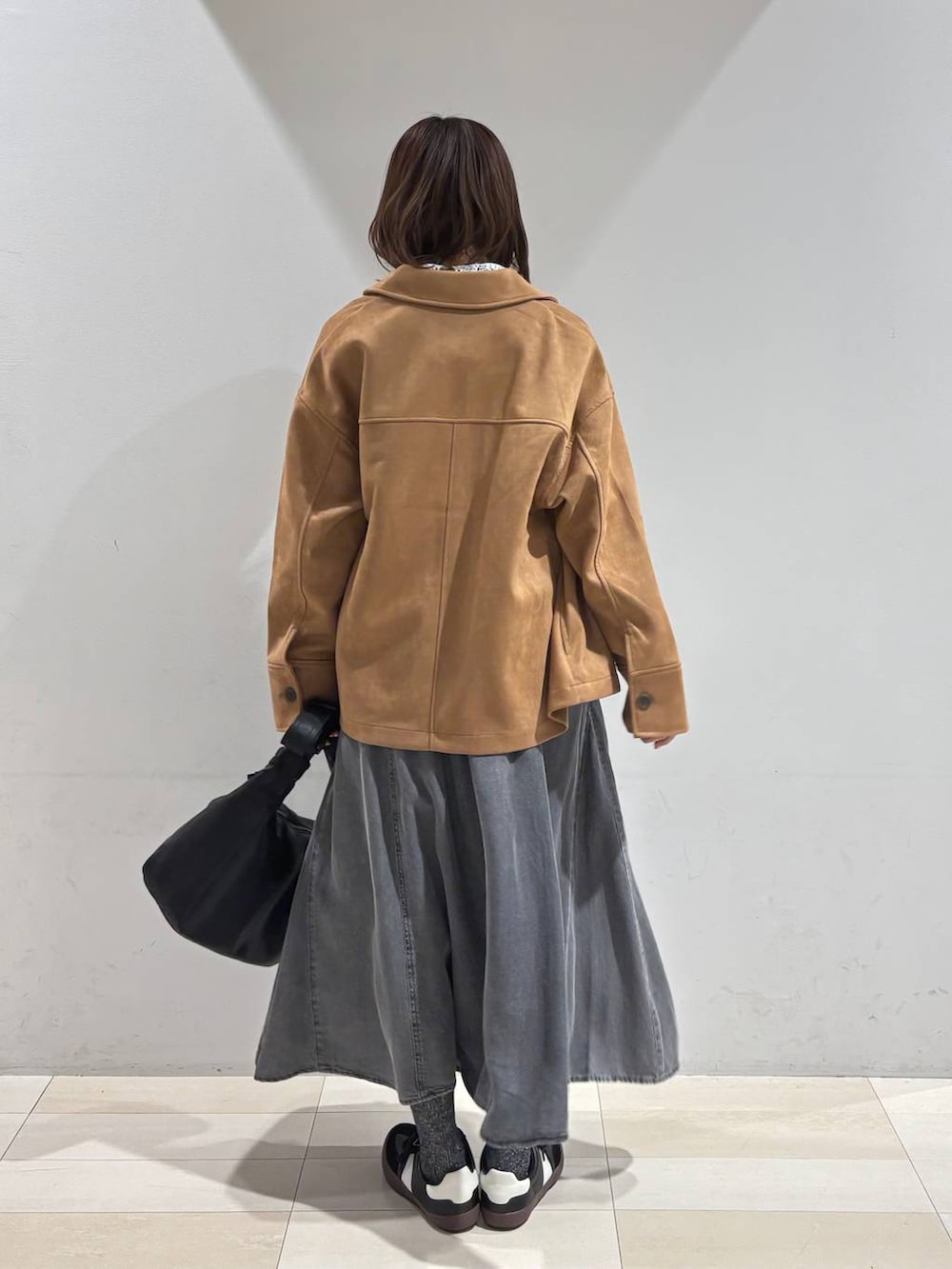 ブラック系のスニーカー、ブラック系のショルダーバッグ、ブラウン系のテーラードジャケットを着用したレディースの冬コーディネートの4枚目の写真