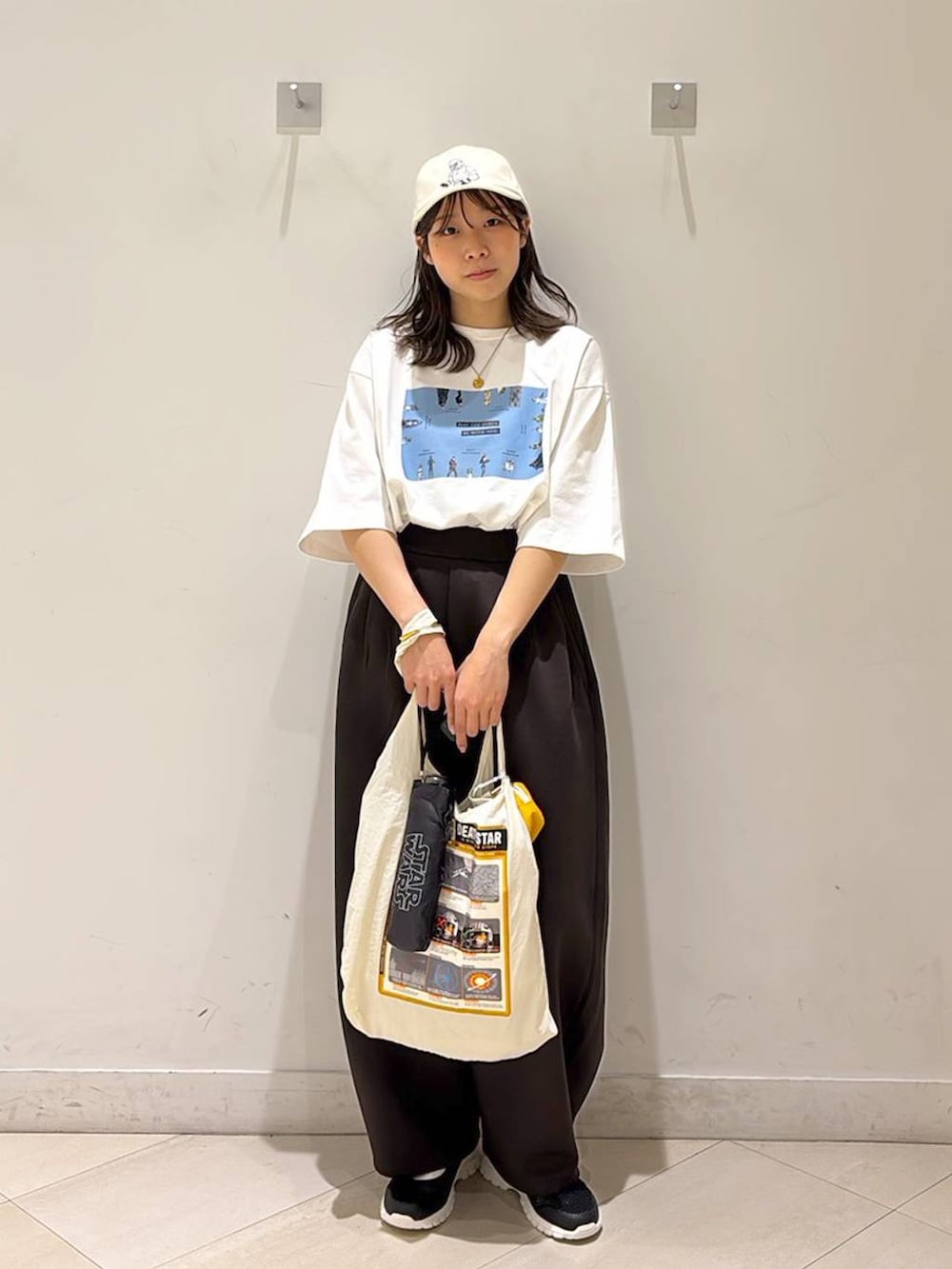 ブラック系のスニーカー、ブラウン系のその他パンツ、ホワイト系のエコバッグ/サブバッグを着用したレディースの春コーディネートの3枚目の写真