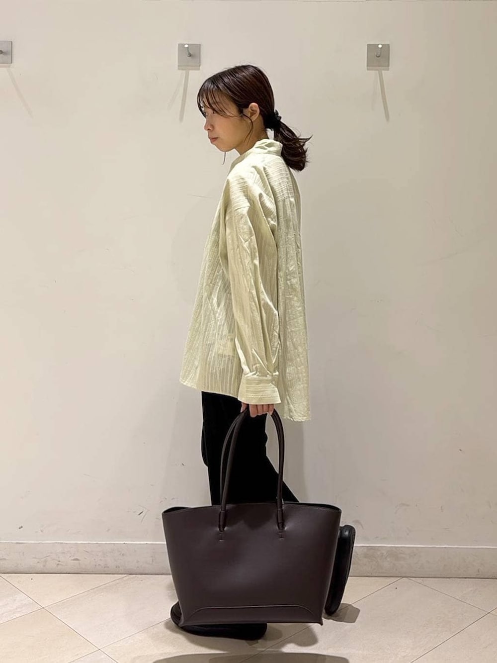 ブラック系のその他パンツ、ブラウン系のトートバッグ、ブラウン系のスニーカーを着用したレディースの春コーディネートの3枚目の写真