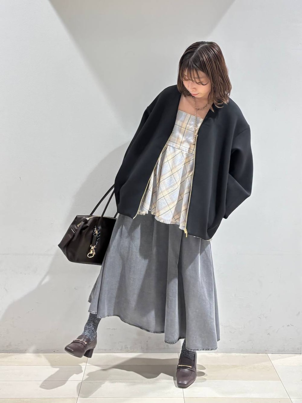 ブラウン系のローファー、ブラウン系のボストンバッグ、ブラック系のブルゾンを着用したレディースの春コーディネートの8枚目の写真