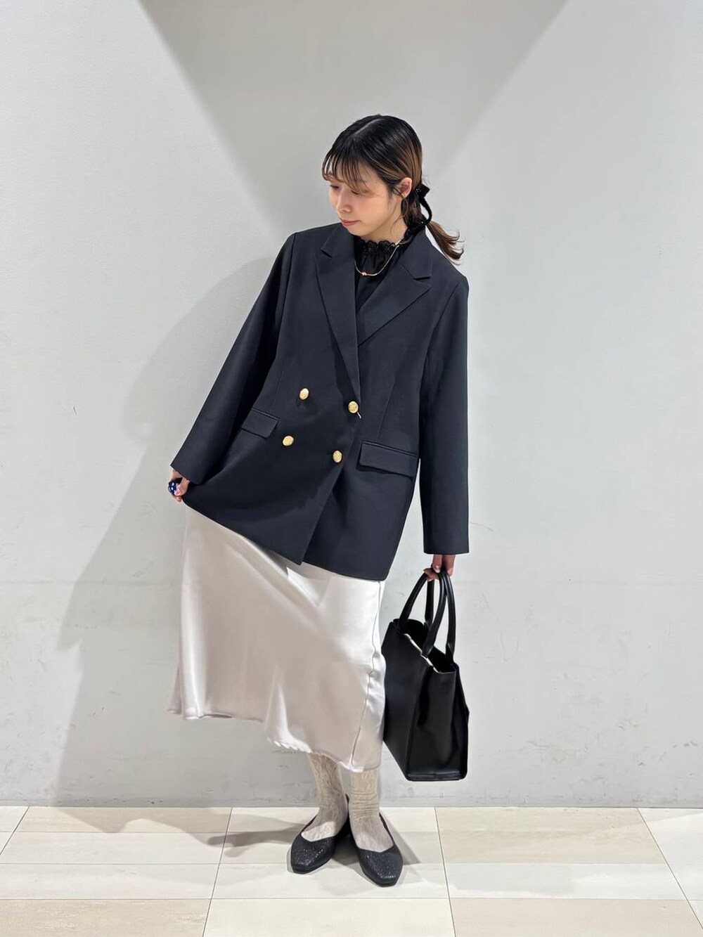 ブラック系のパンプス、ブラック系のシャツ/ブラウス、ブラック系のハンドバッグを着用したレディースの冬コーディネートの8枚目の写真