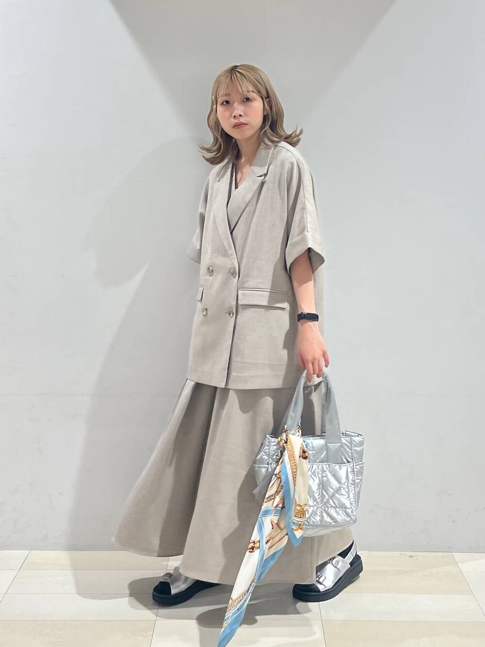 シルバー系のトートバッグ、ホワイト系のキャミソール、シルバー系のサンダルを着用したレディースの夏コーディネートの8枚目の写真