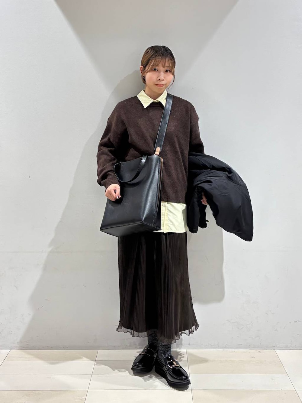 ブラック系のローファー、ブラック系のトートバッグ、ホワイト系のブルゾンを着用したレディースの秋コーディネートの2枚目の写真