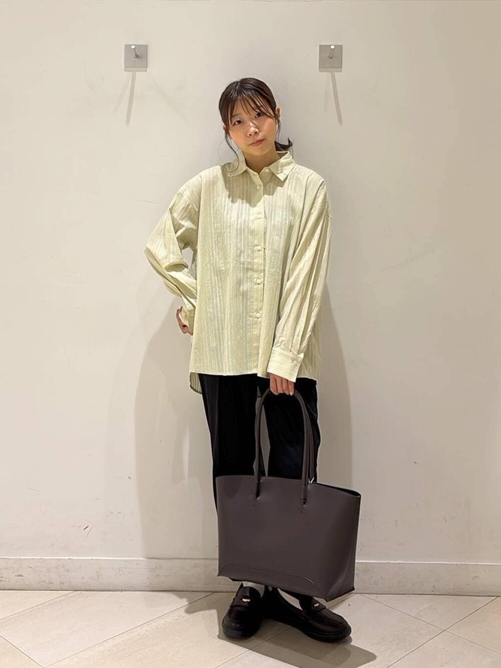 ブラック系のその他パンツ、ブラウン系のトートバッグ、ブラウン系のスニーカーを着用したレディースの春コーディネートの8枚目の写真