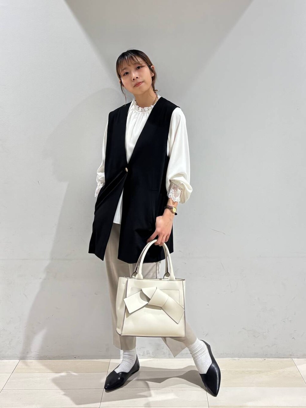 ブラック系のパンプス、ベージュ系のスラックス、ホワイト系のシャツ/ブラウスを着用したレディースの冬コーディネートの7枚目の写真