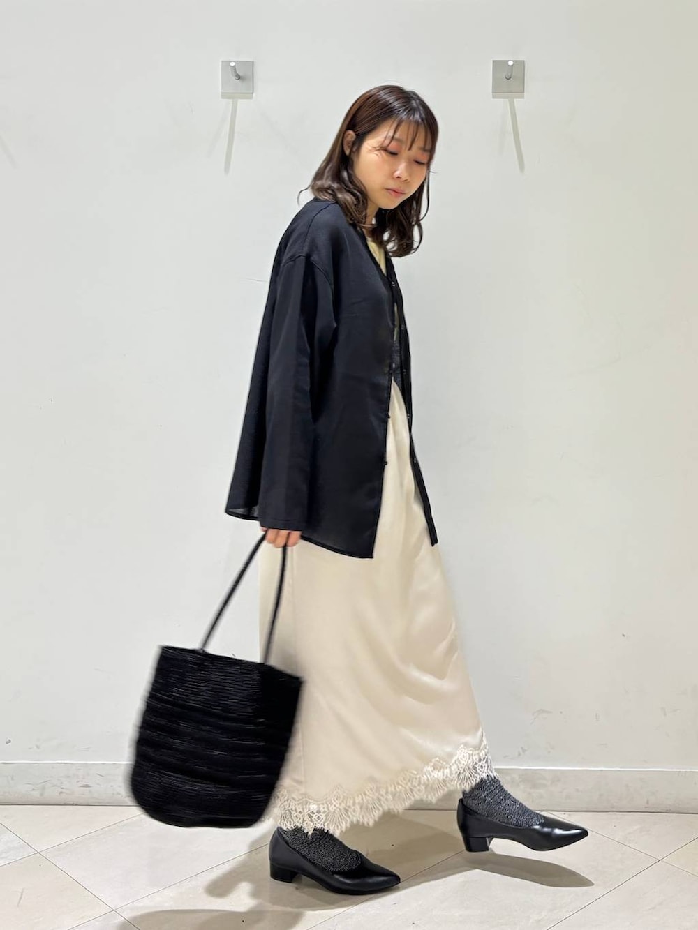 ブラック系のパンプス、ブラック系のクラッチバッグ、ブラック系のカーディガン/ボレロを着用したレディースの夏コーディネートの3枚目の写真