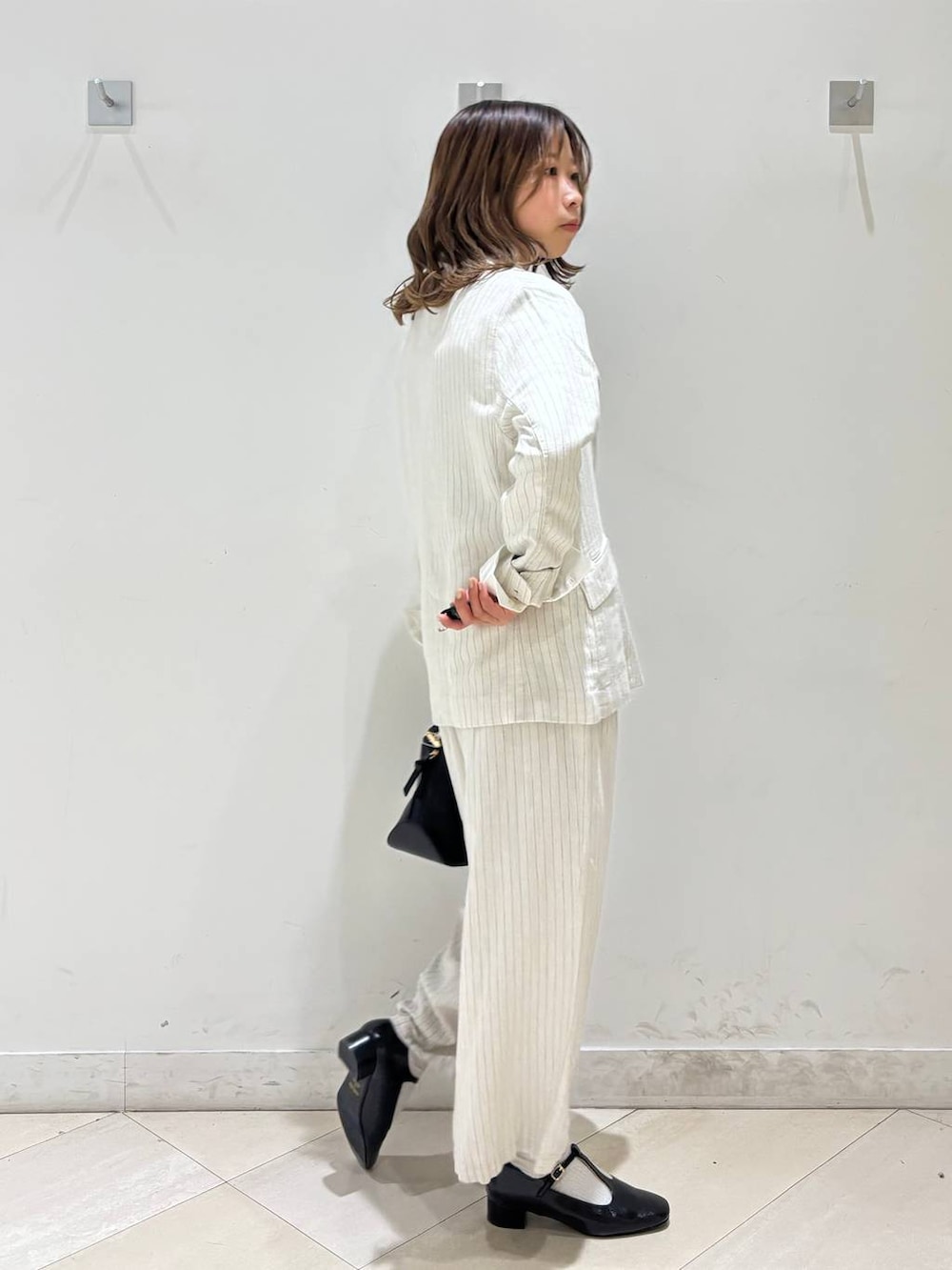 ブラック系のショルダーバッグ、ベージュ系のその他パンツ、グレー系のテーラードジャケットを着用したレディースの春コーディネートの7枚目の写真