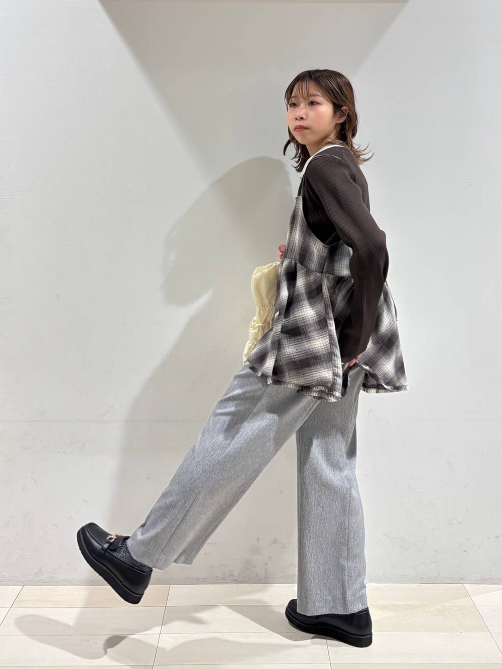 ブラック系のローファー、ベージュ系のトートバッグ、グレー系のその他パンツを着用したレディースの春コーディネートの6枚目の写真