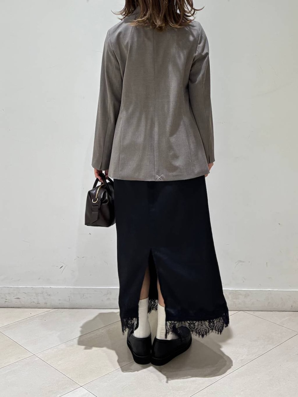 ブラック系のローファー、ブラウン系のテーラードジャケット、ブラウン系のボストンバッグを着用したレディースの春コーディネートの4枚目の写真