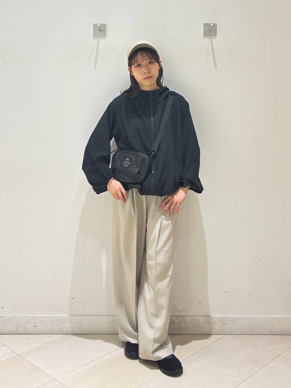ベージュ系のその他パンツ、ブラック系のマウンテンパーカー、ブラック系のスニーカーを着用したレディースの春コーディネートの7枚目の写真