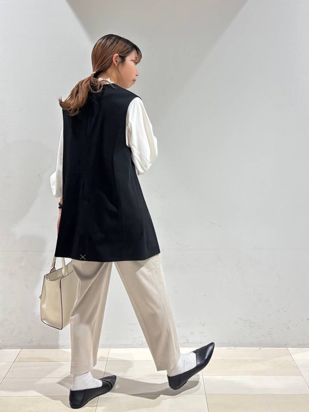 ブラック系のパンプス、ベージュ系のスラックス、ホワイト系のシャツ/ブラウスを着用したレディースの冬コーディネートの4枚目の写真