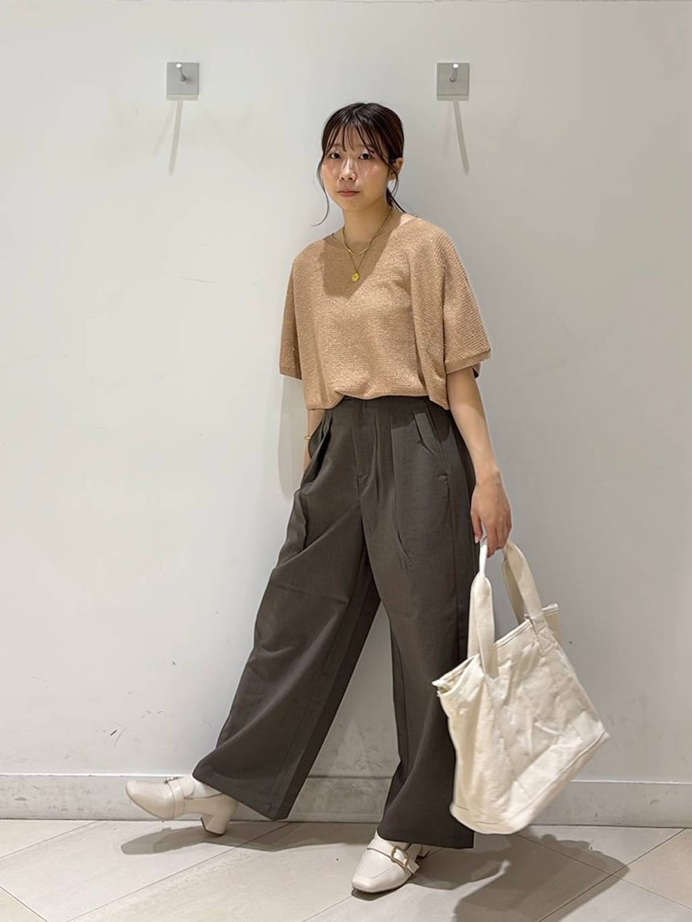 ベージュ系のローファー、ホワイト系のトートバッグ、オレンジ系のニット/セーターを着用したレディースの春コーディネートの4枚目の写真