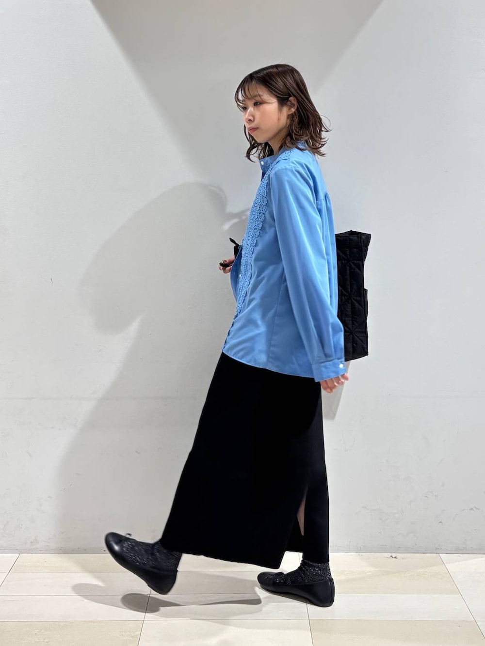 ブラック系のバレエシューズ、ブラック系のトートバッグ、ブラック系のスカートを着用したレディースの冬コーディネートの6枚目の写真