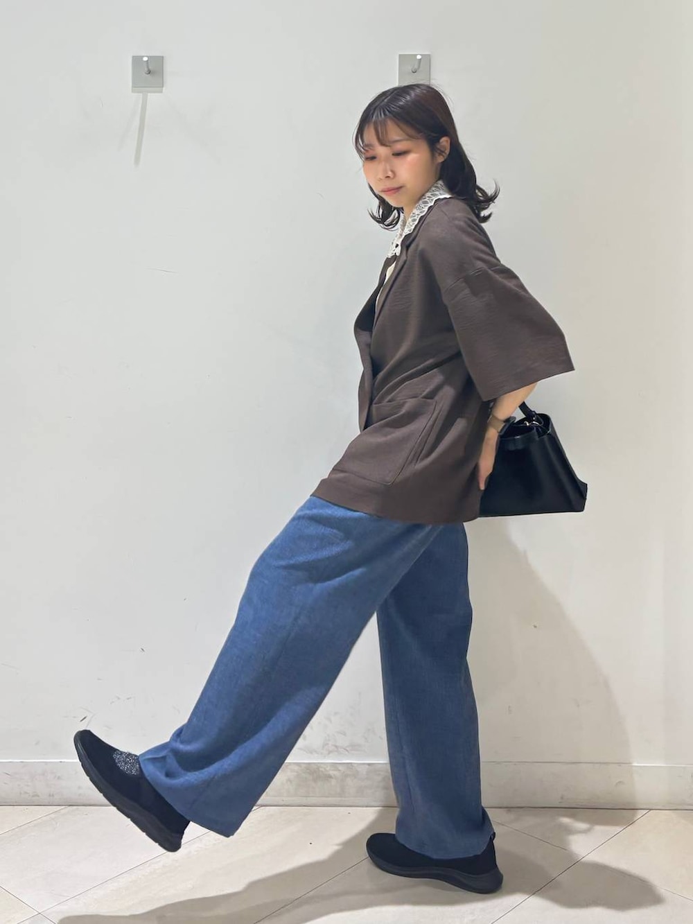 ブラック系のショルダーバッグ、ブルー系のその他パンツ、ブラウン系のテーラードジャケットを着用したレディースの春コーディネートの7枚目の写真
