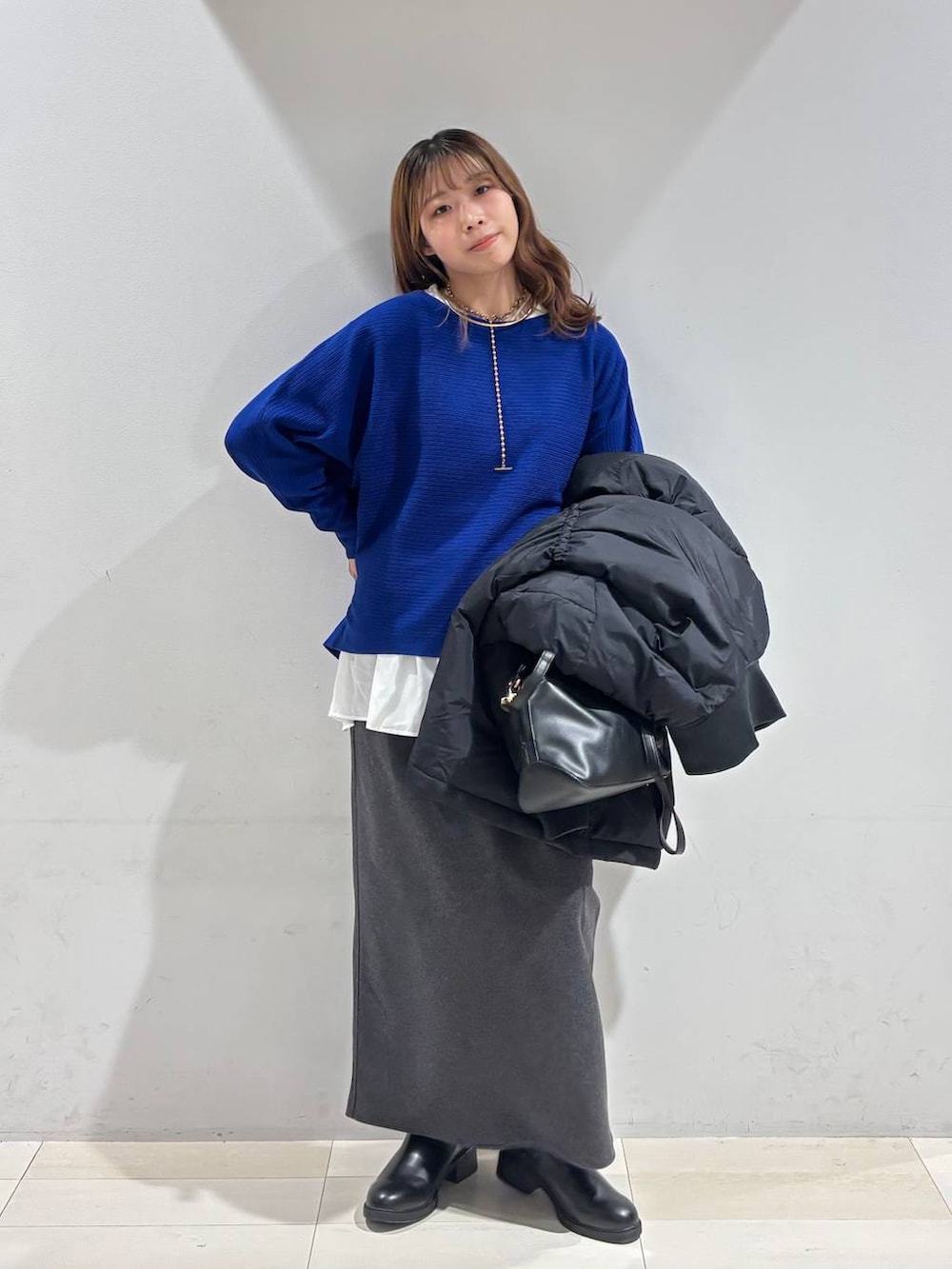 ブラック系のショルダーバッグ、ブラック系のダウンジャケット/コート、ホワイト系のTシャツ/カットソーを着用したレディースの冬コーディネートの2枚目の写真