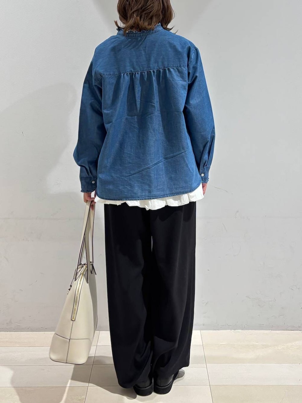 ブラック系のローファー、ベージュ系のボストンバッグ、ブルー系のシャツ/ブラウスを着用したレディースの春コーディネートの5枚目の写真