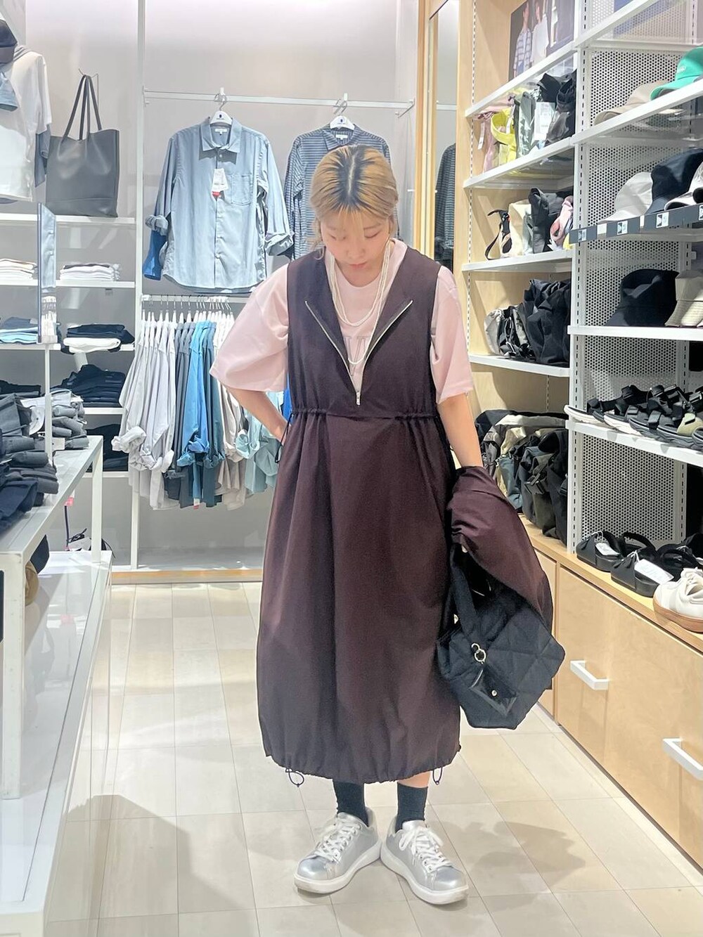 シルバー系のスニーカー、ブラック系のトートバッグ、ピンク系のTシャツ/カットソーを着用したレディースの夏コーディネートの3枚目の写真