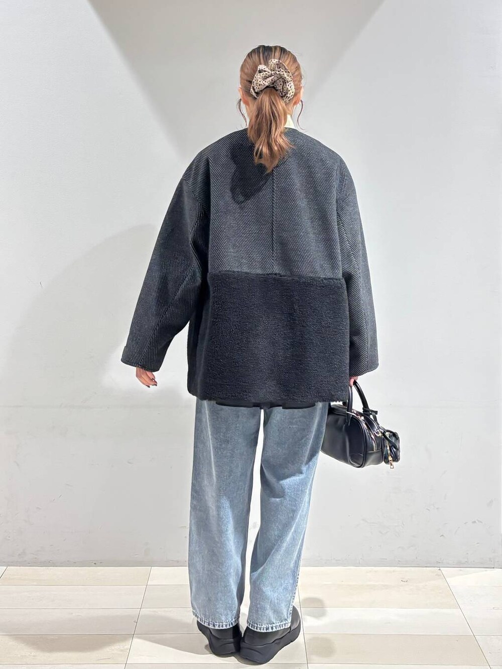 ブルー系のデニムパンツ、ブラック系のブーツ、ブラック系のTシャツ/カットソーを着用したレディースの冬コーディネートの7枚目の写真