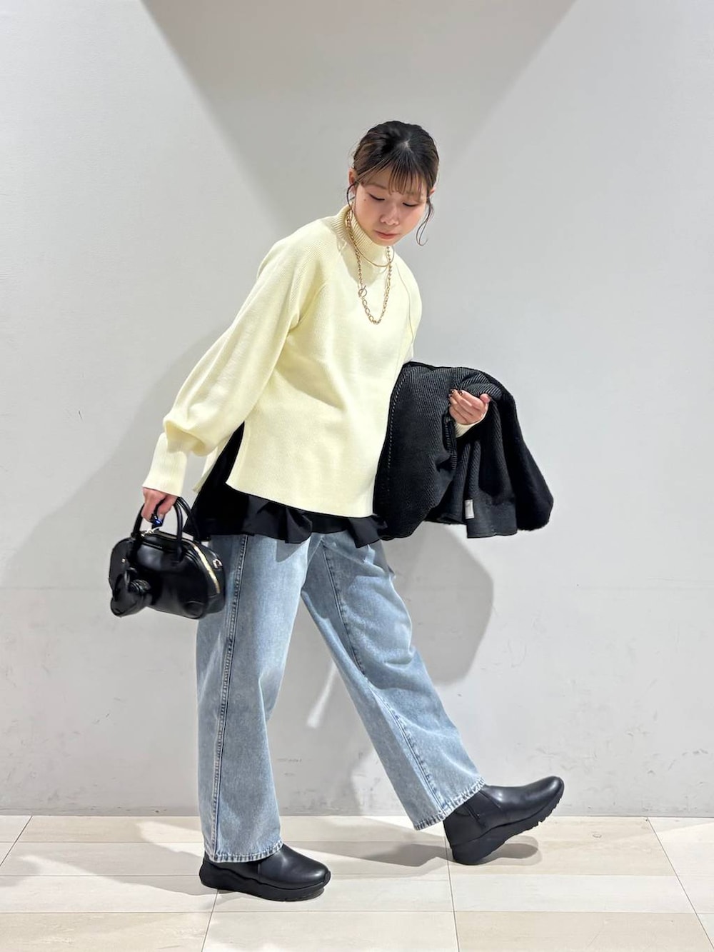 ブルー系のデニムパンツ、ブラック系のブーツ、ブラック系のTシャツ/カットソーを着用したレディースの冬コーディネートの4枚目の写真