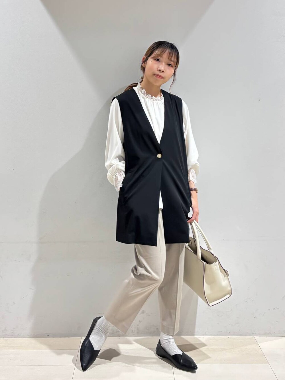 ブラック系のパンプス、ベージュ系のスラックス、ホワイト系のシャツ/ブラウスを着用したレディースの冬コーディネートの8枚目の写真