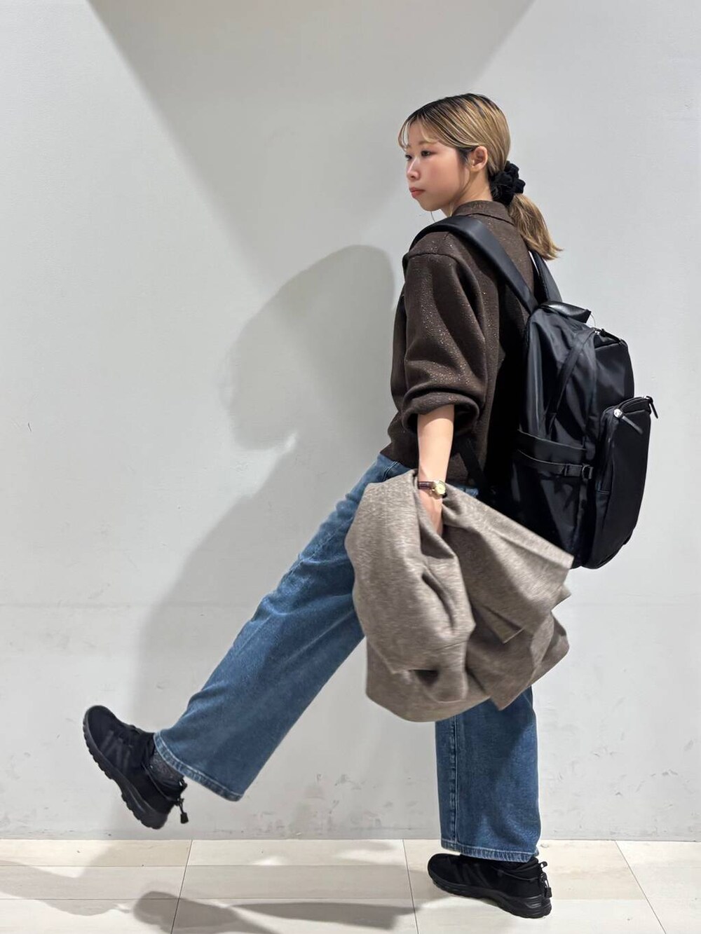 ブラック系のバックパック/リュック、ブラウン系のチェスターコート、ブラウン系のワンピースを着用したレディースの秋コーディネートの4枚目の写真