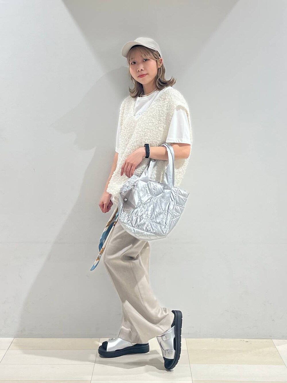 シルバー系のトートバッグ、シルバー系のサンダル、ベージュ系のその他パンツを着用したレディースの夏コーディネートの3枚目の写真