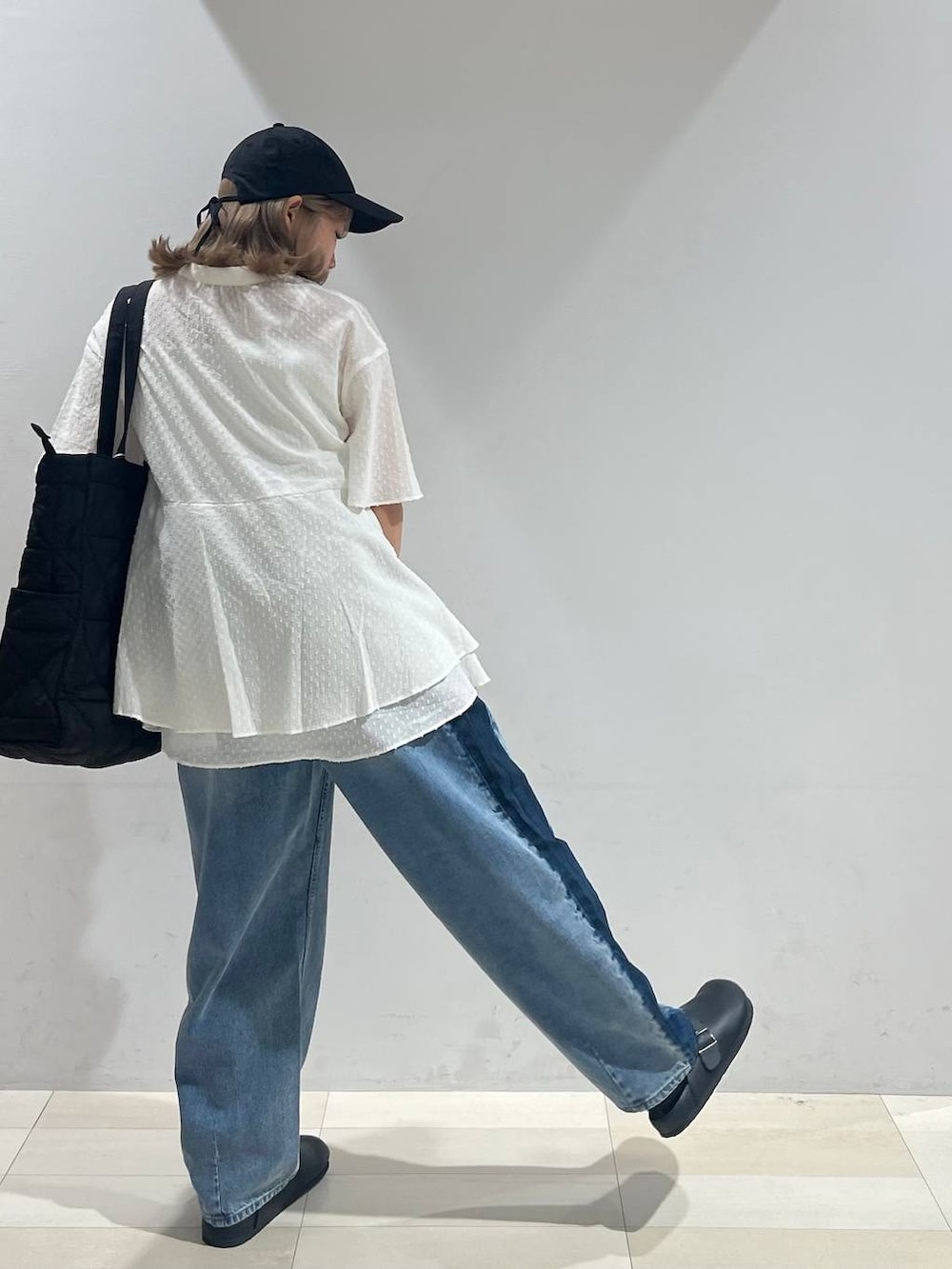 ブラック系のトートバッグ、ホワイト系のキャミソール、ブラック系のサンダルを着用したレディースの夏コーディネートの4枚目の写真