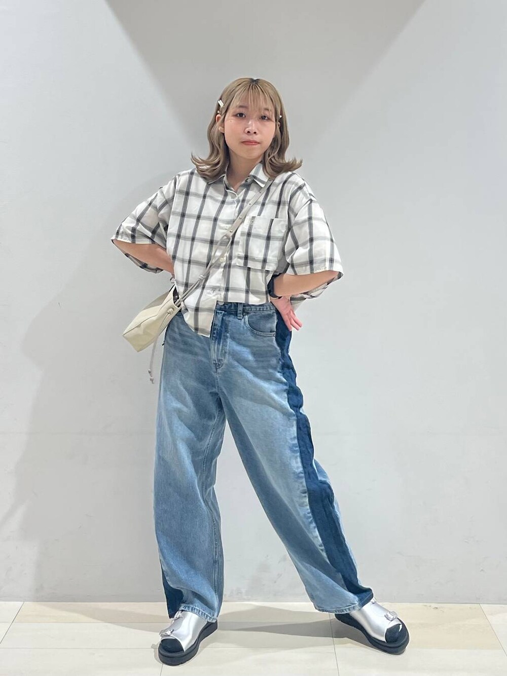 シルバー系のサンダル、ベージュ系のショルダーバッグ、ブルー系のデニムパンツを着用したレディースの夏コーディネートの2枚目の写真