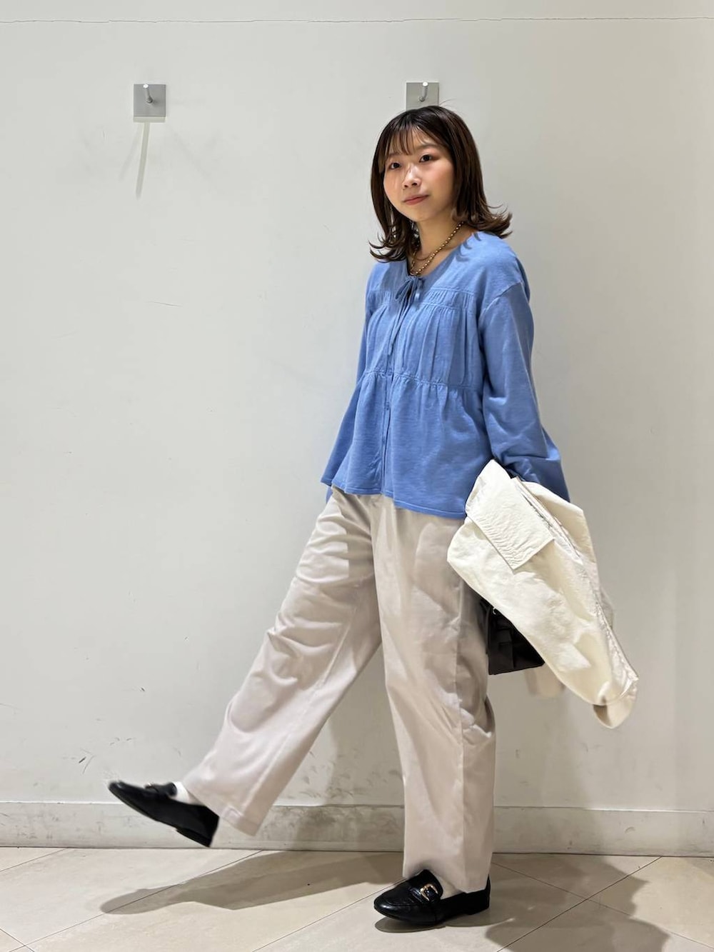 ブラック系のローファー、ホワイト系のその他パンツ、ブラウン系のボストンバッグを着用したレディースの春コーディネートの3枚目の写真