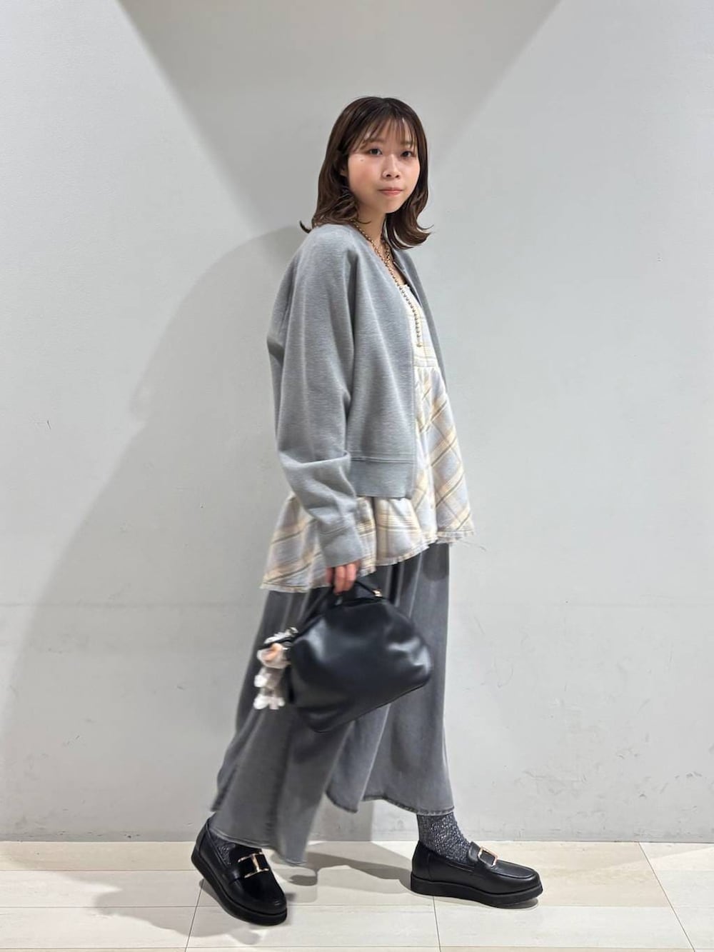 ブラック系のショルダーバッグ、ブラック系のローファー、ブルー系のその他トップスを着用したレディースの春コーディネートの6枚目の写真