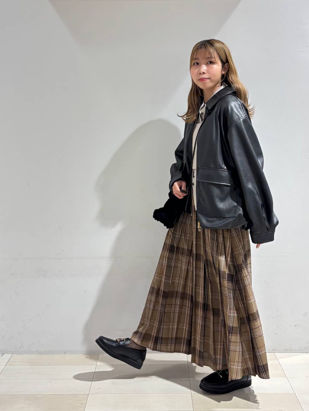 ベージュ系のTシャツ/カットソー、ブラック系のローファー、ブラック系のブルゾンを着用したレディースの秋コーディネートの3枚目の写真