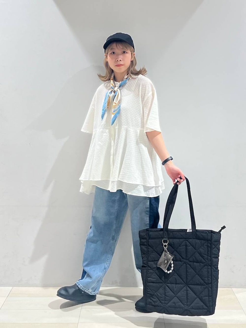 ブラック系のトートバッグ、ホワイト系のキャミソール、ブラック系のサンダルを着用したレディースの夏コーディネートの2枚目の写真