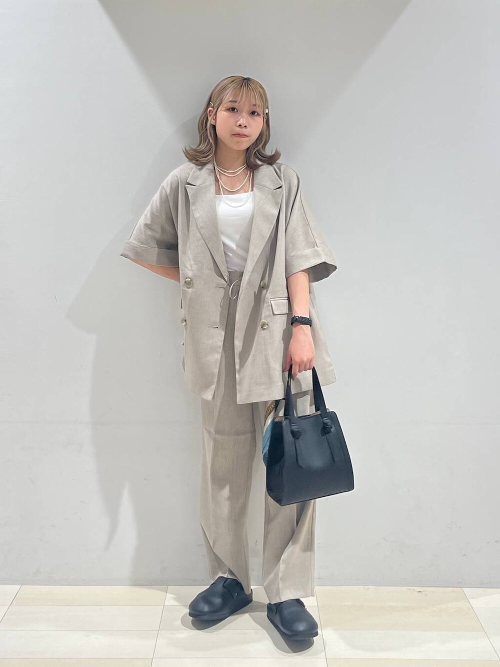 ブラック系のショルダーバッグ、ホワイト系のキャミソール、ブラック系のサンダルを着用したレディースの夏コーディネートの6枚目の写真