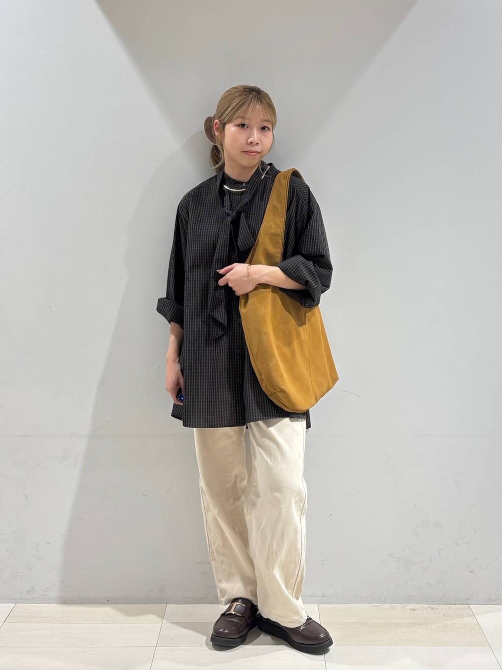 ベージュ系のデニムパンツ、ブラウン系のローファー、イエロー系のトートバッグを着用したレディースの夏コーディネートの7枚目の写真