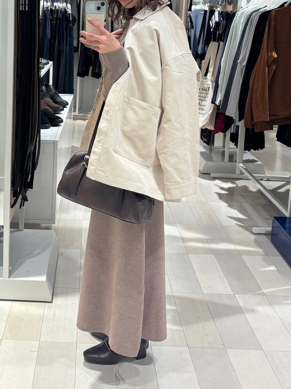 ブラウン系のローファー、ホワイト系のデニムジャケット、ブラウン系のショルダーバッグを着用したレディースの春コーディネートの3枚目の写真