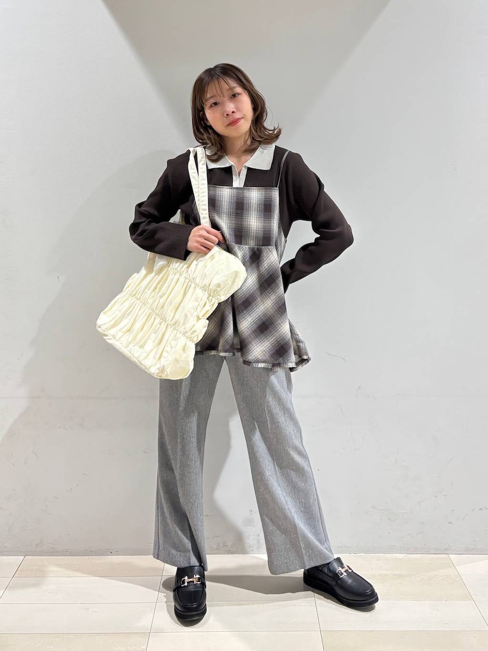 ブラック系のローファー、ベージュ系のトートバッグ、グレー系のその他パンツを着用したレディースの春コーディネートの2枚目の写真