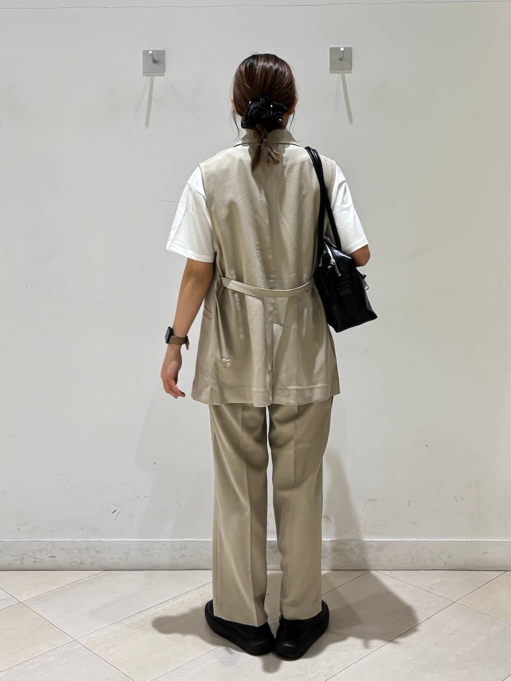 ブラック系のボストンバッグ、ベージュ系のその他パンツ、ベージュ系のベストを着用したレディースの春コーディネートの4枚目の写真