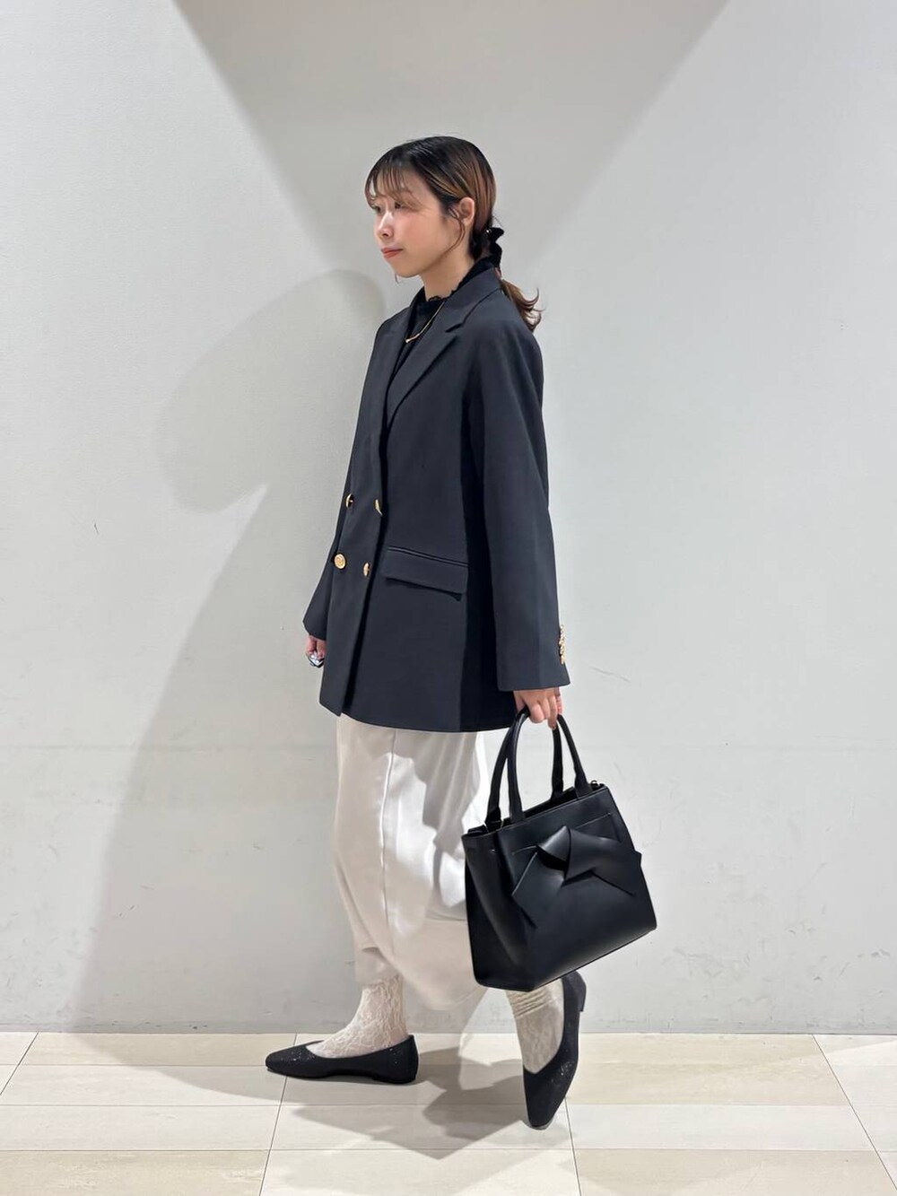 ブラック系のパンプス、ブラック系のシャツ/ブラウス、ブラック系のハンドバッグを着用したレディースの冬コーディネートの4枚目の写真